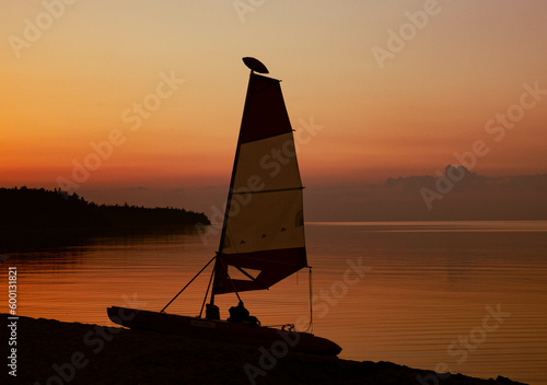 Sailboard near lake in sunset