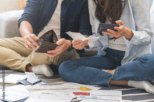 Canvas Print Stressed financial owe asian young couple love sitting stressed and confused by hand hold wallet calculate expense from invoice , no money to pay, mortgage or loan