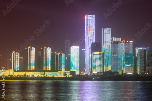 night view of high-rise buildings along Liuyang River near the junction with Xiangjiang river, Changsha, Hunan, China photo