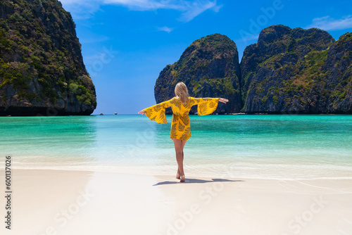 Foto Beautiful young blonde woman in orange dress on a Maya Bay Beach during excursion of phi phi leh island in andaman sea thailand