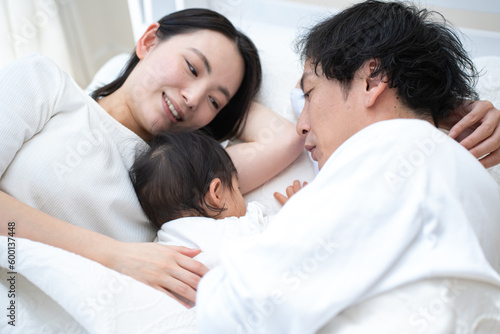 ベッドで子供の面倒を見る日本人の親子