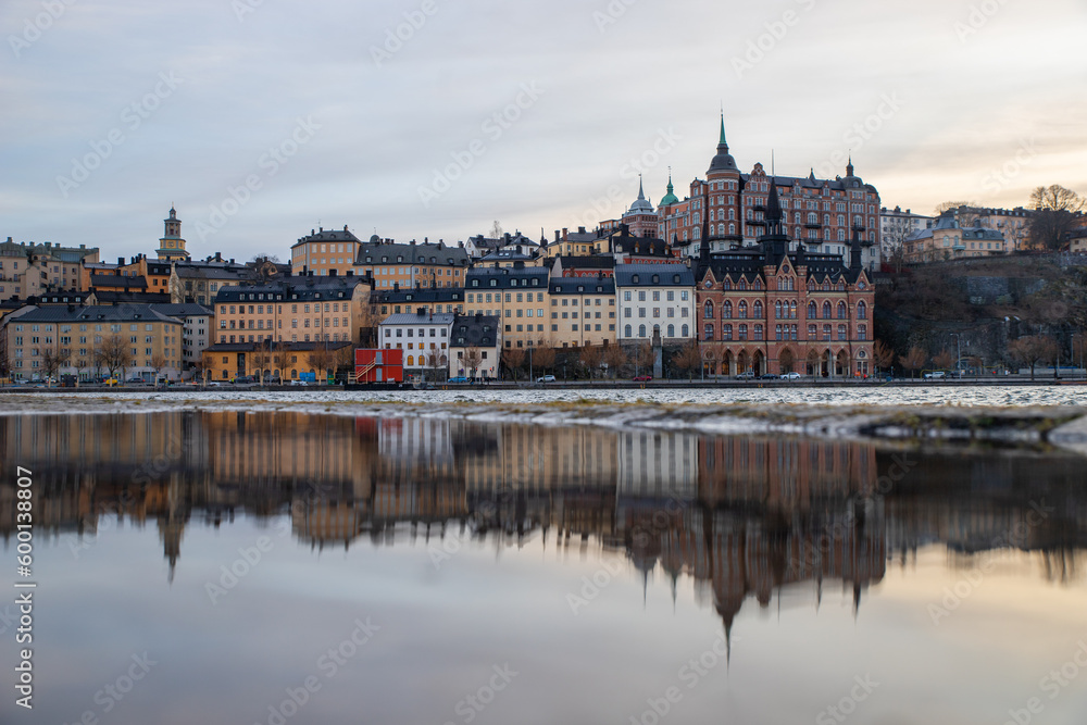 The tranquil sea mirrors the serene charm of the shore houses in Stockholm, creating a captivating reflection of peace and beauty.