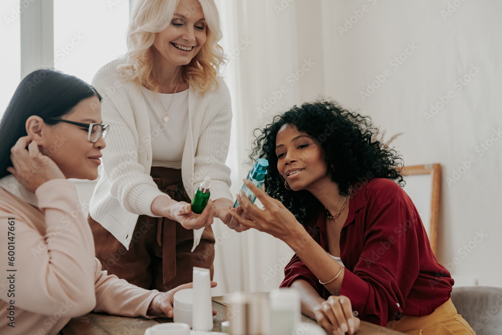 Confident mature woman advising beauty products to friends while spending time together Confident mature woman advising beauty products to friends while spending time together