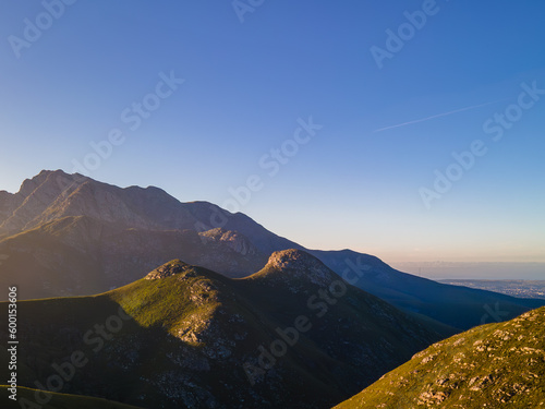 Sun rising over Cradock Peak in the Majestic Outeniqua Mountains, With the City George down towards the sea.  George Western Cape, South Africa, May 2023 photo