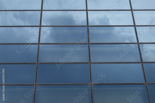 glass facade of modern building with sky reflections abstract background
