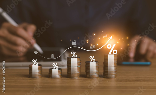 interest rates and dividends, investment returns, income, retirement Compensation fund, investment, dividend tax. pile of coins and upward direction percentage symbol. saving money for investment