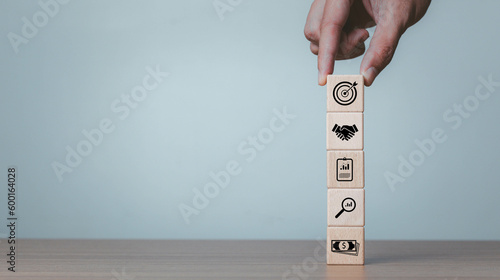 Wood cube block stacking with icon. business strategy and action plan Concept. Businessman hand arranging wood block with icon business strategy and Action plan, copy space. 
