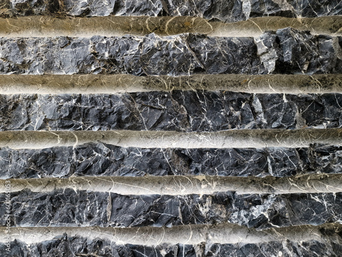 Fondo con detalle y textura de superficie de piedra oscura con surcos horizontales