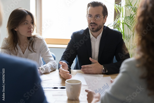 Foto Department brainstorming in office board room, staff led by male CEO discussing