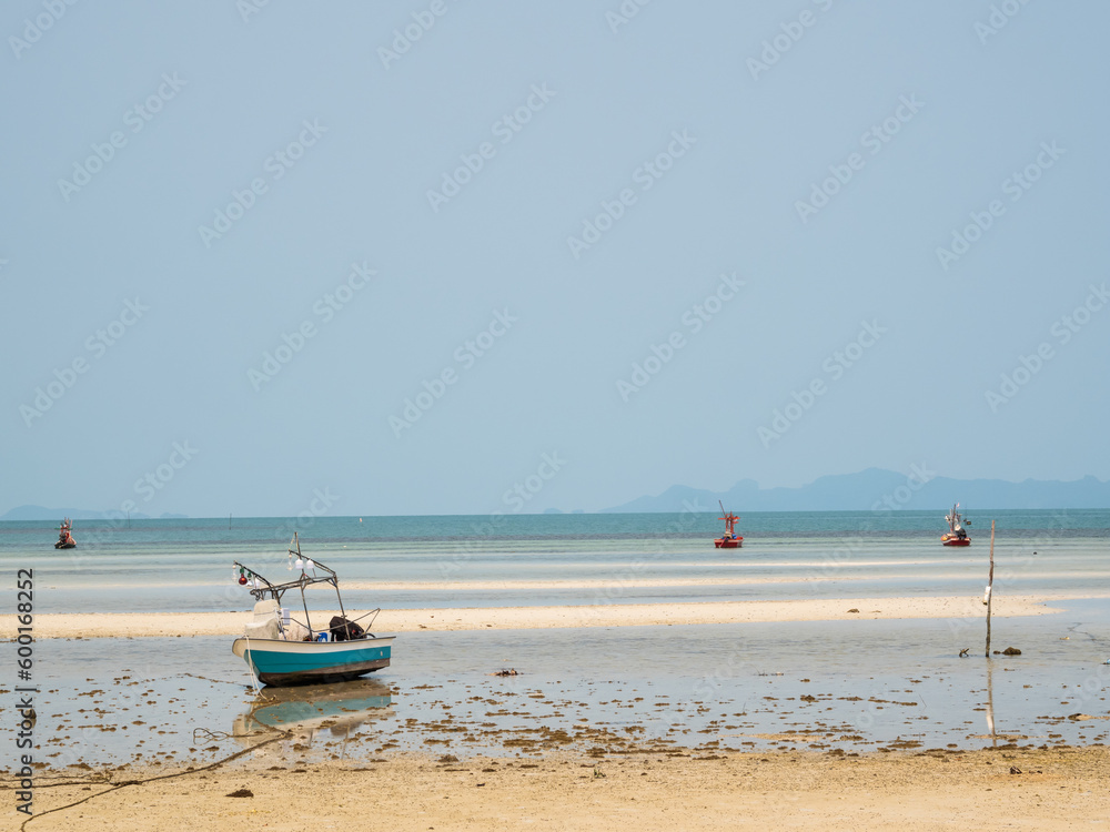 Wooden boat moored on the beach by the sea There is a vast sky in the background Wooden boat moored on the beach by the sea There is a vast sky in the background