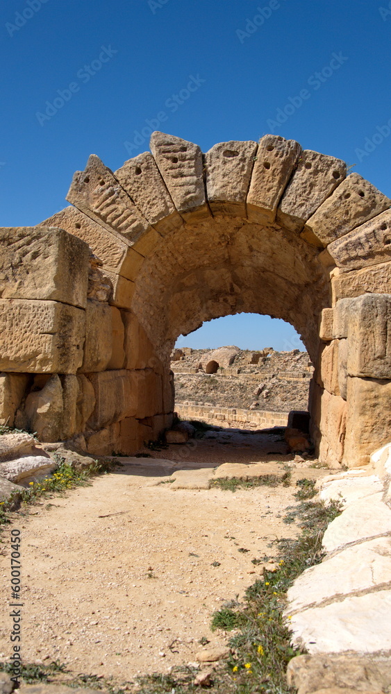 Stone arch over an entrance to the amphitheater in the Roman ruins at Uthina, outside of Tunis, Tunisia