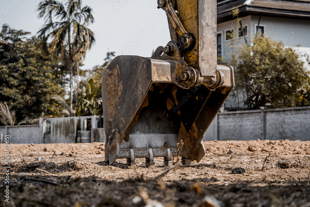 Fototapeta premium Excavator with shovel digs the ground for the foundation at constuction area.