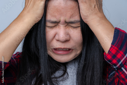 Asian women suffer from severe headaches that can be caused by stress or anxiety, migraines, and chronic headaches. Close your eyes and touch your temples to relieve pain.