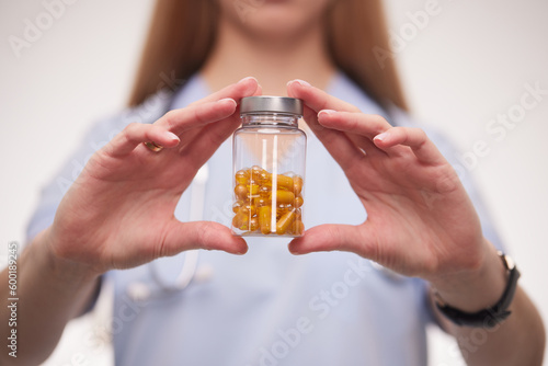 doctor holding a bottle of pills in his hands close-up
