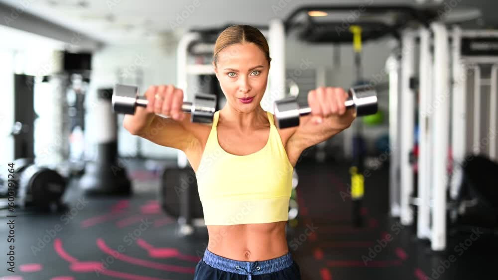 Beautiful young woman doing various exercises lifting dumbbells Beautiful young woman doing various exercises lifting dumbbells