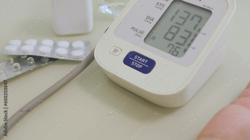 Senior adult woman measures her blood pressure on an automatic blood pressure monitor, close up view Senior adult woman measures her blood pressure on an automatic blood pressure monitor, close up view