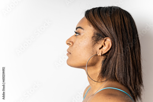 A portrait of a close-up profile of a dark-skinned girl with short straight hair on a white background. Concept of African women, profile view. Copyspace.