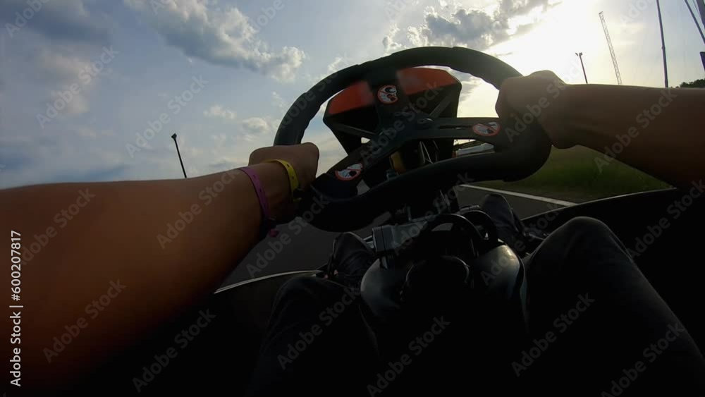 Man is driving a speedy go-cart on the race track outdoors