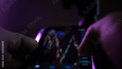A man holds a smartphone in his hands, buys stocks, deals with crypto and trading.