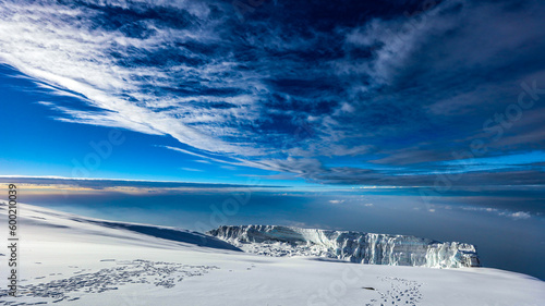 Glacier and snow on top of Mount Kilimanjaro with clouds and blue sky in the background