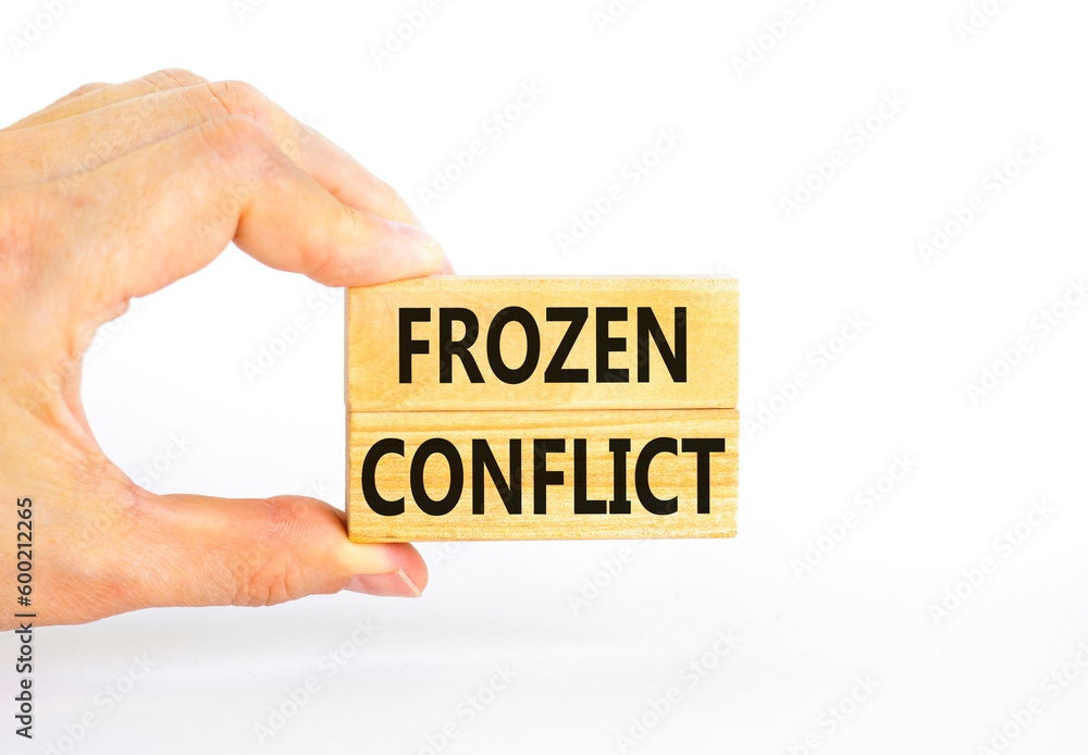 Frozen conflict symbol. Concept words Frozen conflict on beautiful wooden block. Beautiful white table white background. Businessman hand. Business and Frozen conflict concept. Copy space. Frozen conflict symbol. Concept words Frozen conflict on beautiful wooden block. Beautiful white table white background. Businessman hand. Business and Frozen conflict concept. Copy space.