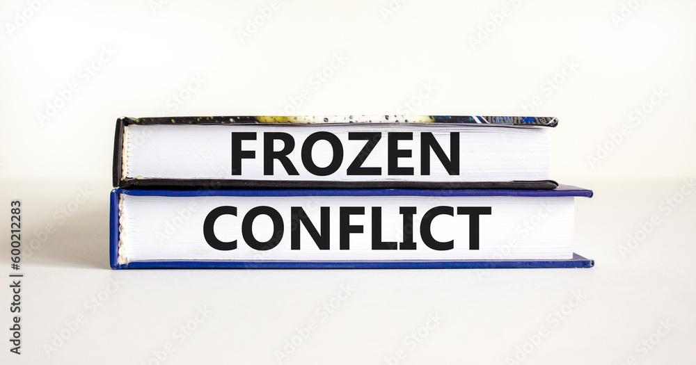 Frozen conflict symbol. Concept words Frozen conflict on beautiful books. Beautiful white table white background. Business and Frozen conflict concept. Copy space.