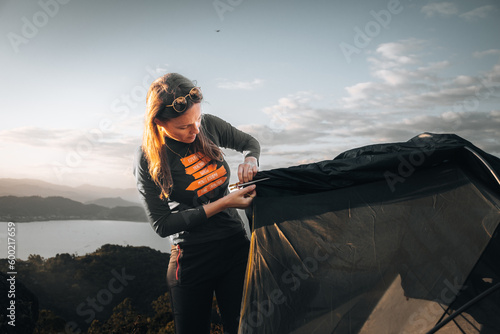 Mulher montando barraca em acampamento ao ar livre na montanha. photo