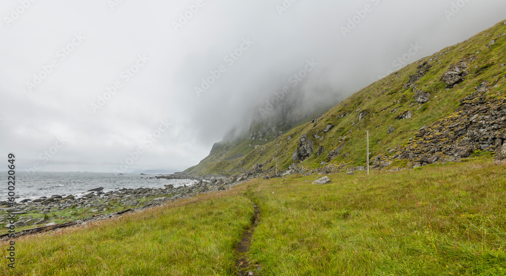 View on a rocky beach on Vaeroy island ( Værøy ) on Lofoten archipelago with a moody stormy sky. Boulders, rocks, Norway, wilderness. Bad weather. day, summer. copy space, negative space View on a rocky beach on Vaeroy island ( Værøy ) on Lofoten archipelago with a moody stormy sky. Boulders, rocks, Norway, wilderness. Bad weather. day, summer. copy space, negative space