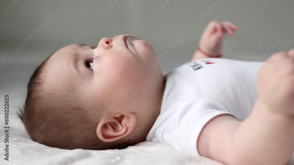 baby boy adorable newborn infant lying on bed looking up.mother kissing kid cheek,tenderness,caresses.toddler is talking something moving lips,close up face portrait 4k.woman hand on body, tongue out baby boy adorable newborn infant lying on bed looking up.mother kissing kid cheek,tenderness,caresses.toddler is talking something moving lips,close up face portrait 4k.woman hand on body, tongue out