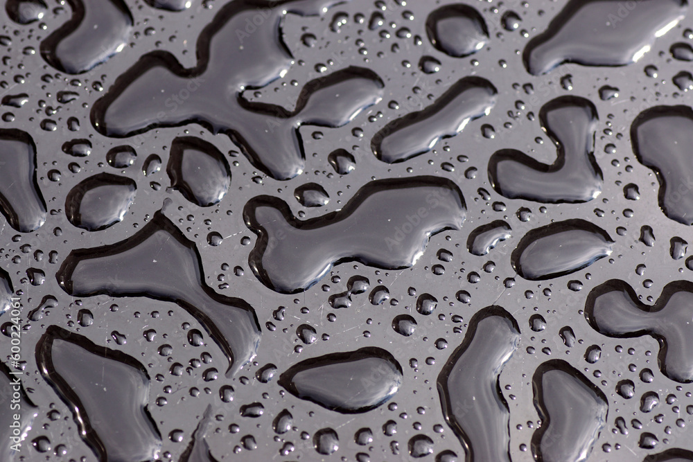 Close up of the texture of rainwater, raindrops on a black glass table with scratches. Pattern Close up of the texture of rainwater, raindrops on a black glass table with scratches. Pattern