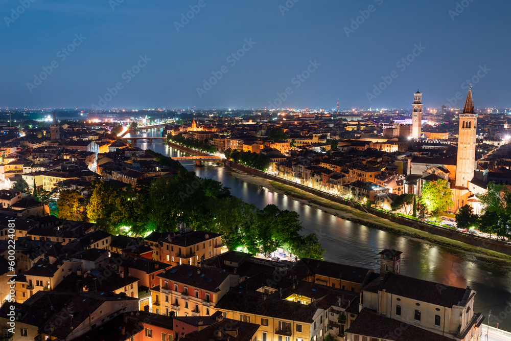 Famous old town of Verona at night. Colorful city lights reflecting in the river Adige. Long exposure.