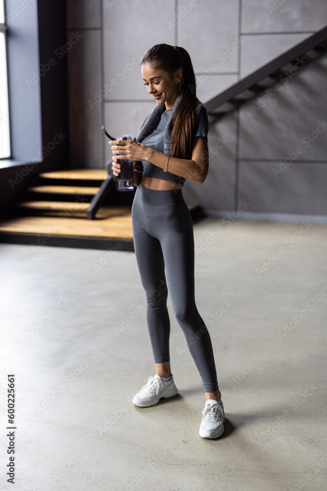 Portrait of sporty beautiful smiling woman in sportswear and white towel on neck Portrait of sporty beautiful smiling woman in sportswear and white towel on neck