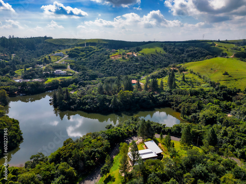 Aerial image of pine trees and houses in the middle of the forest in the interior of Brazil. Green, blue sky and immensity. City Joaquim Egidio next to Sousas. photo