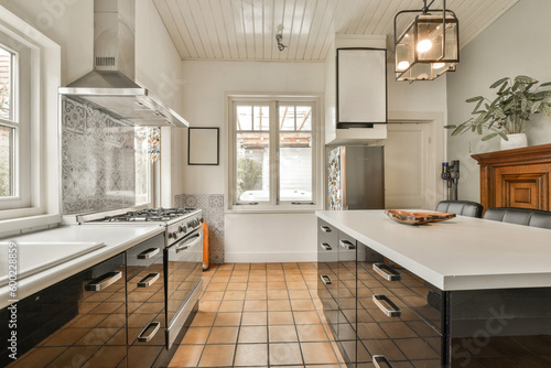 a kitchen with black and white tiles on the floor  along with an island in the center of the room