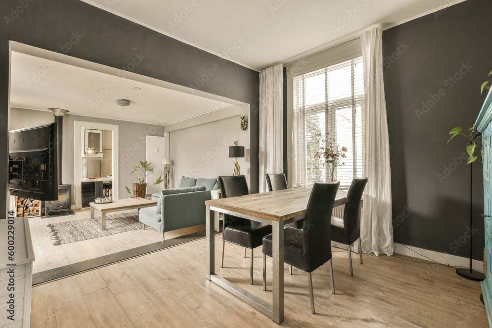 Fototapeta premium a dining room with black walls and white trim on the walls, wood floors and hardwood flooring in an open living area