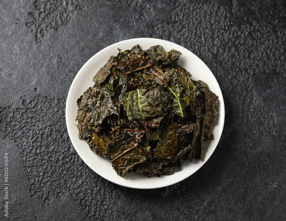 A delicious Kale chips, snack on white plate. Healthy vegetable food. A delicious Kale chips, snack on white plate. Healthy vegetable food.