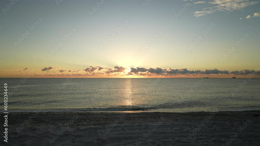 sun peaking behind clouds at the beach in slow motion during the sun rise sun peaking behind clouds at the beach in slow motion during the sun rise