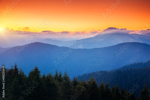 Fototapeta Naklejka Na Ścianę i Meble -  A majestic view of the mountain ranges illuminated by the sunset.