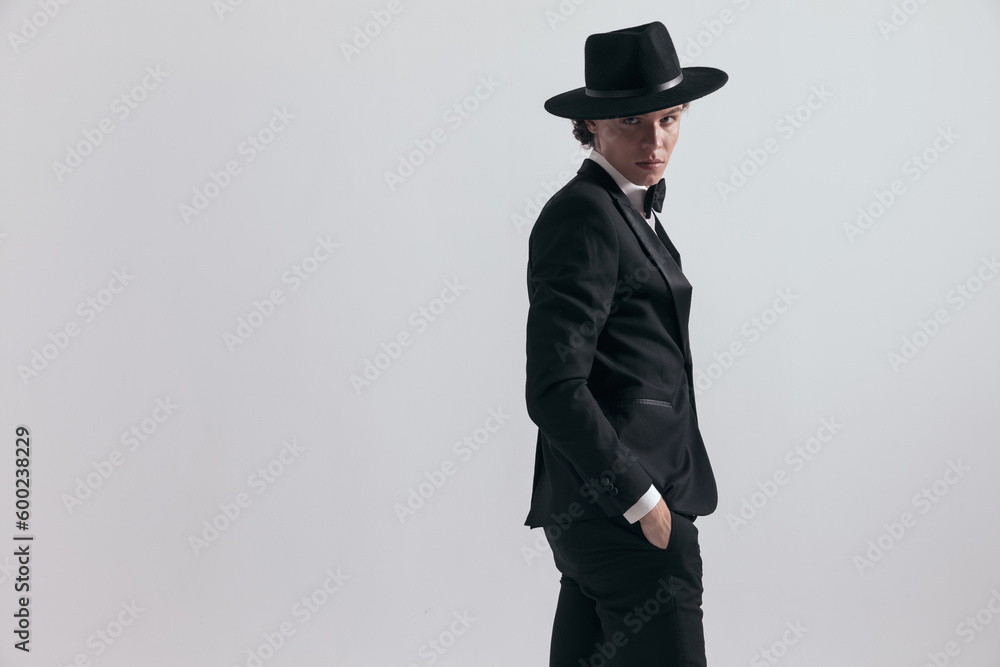 portrait of elegant best man wearing hat and posing with hands in pockets portrait of elegant best man wearing hat and posing with hands in pockets