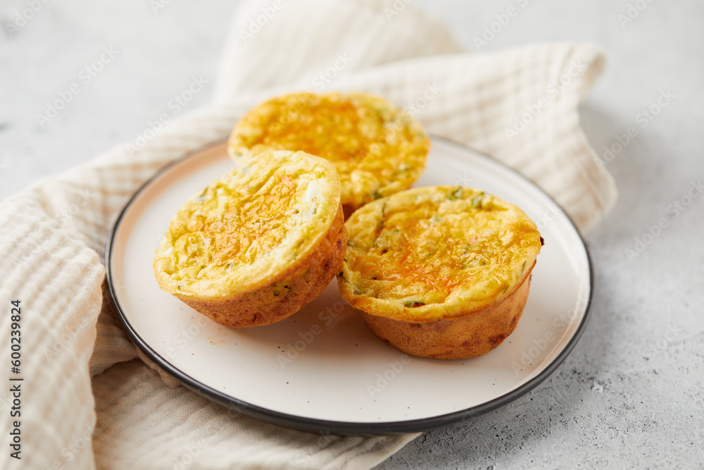 Savory muffins with egg, feta cheese, cheddar and spinach on light background Savory muffins with egg, feta cheese, cheddar and spinach on light background