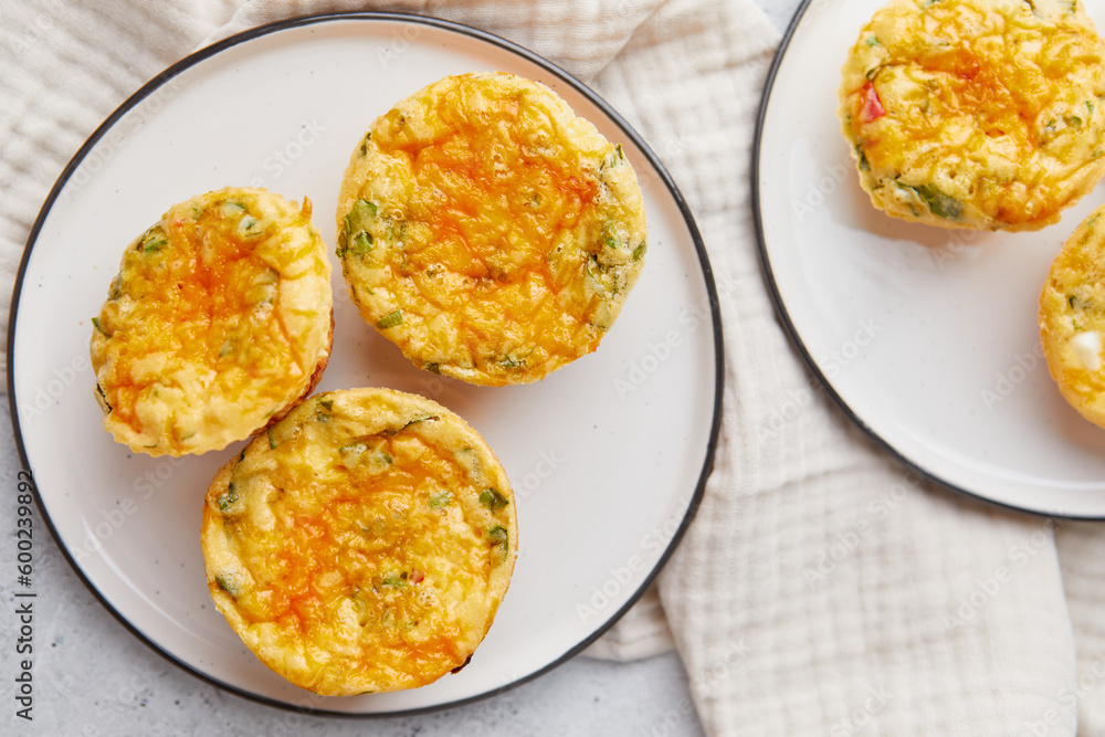 Savory muffins with egg, feta cheese, cheddar and spinach on light background Savory muffins with egg, feta cheese, cheddar and spinach on light background