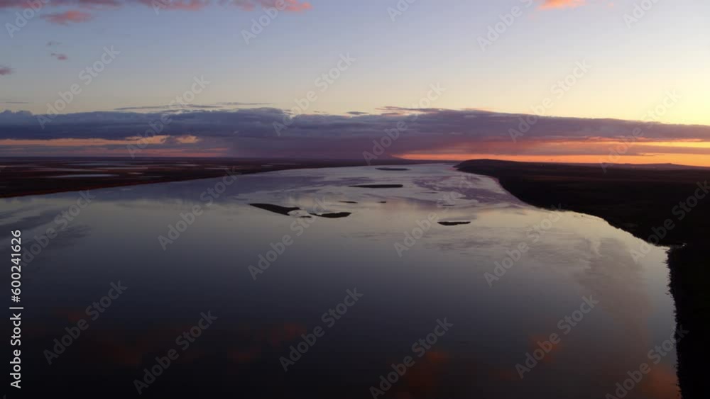 Aerial Shot Of Sea By Silhouette Landscape Against Sky At Sunset, Drone Flying Over Water With Reflection - Bering Sea, Alaska Aerial Shot Of Sea By Silhouette Landscape Against Sky At Sunset, Drone Flying Over Water With Reflection - Bering Sea, Alaska