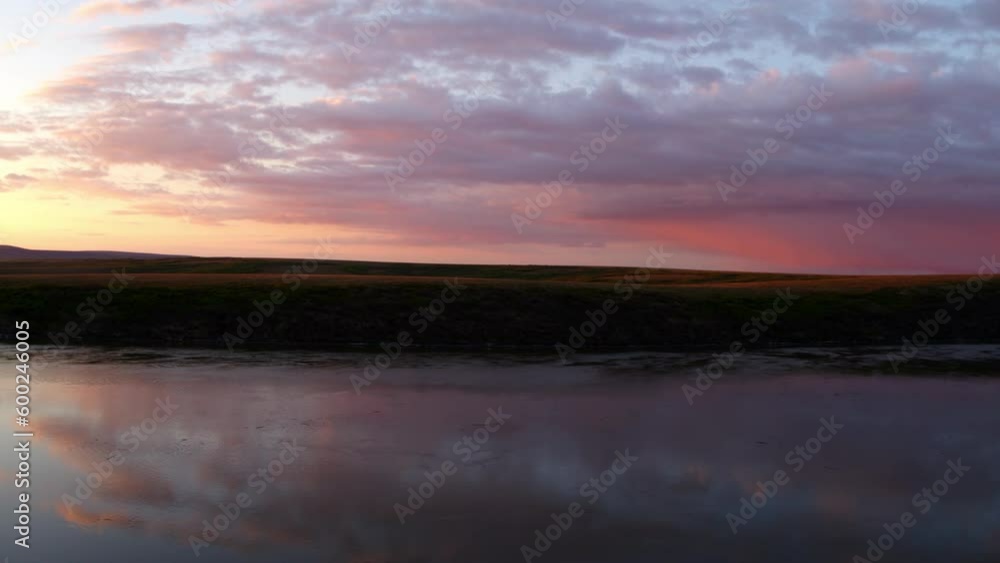 Aerial: Drone Panning Shot Of Sea With Reflection Near Silhouette Land Against Sky During Sunset - Bering Sea, Alaska Aerial: Drone Panning Shot Of Sea With Reflection Near Silhouette Land Against Sky During Sunset - Bering Sea, Alaska