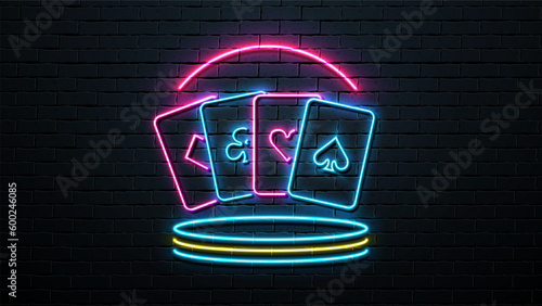 Neon poker cards on the platform. A bright composition on the theme of a casino on the background of a brick wall.
