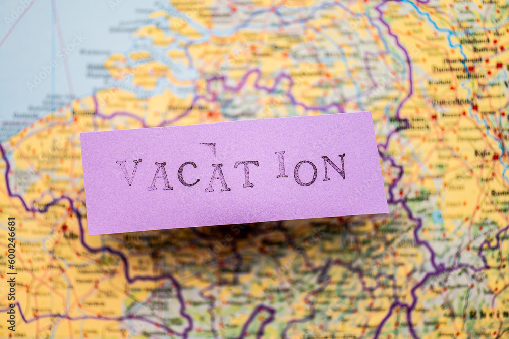 Vacation stencil text on purple paper over a map.