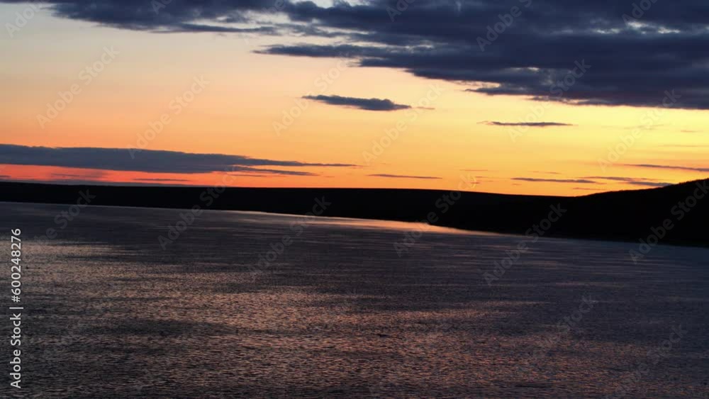 Aerial Shot Of Rippled Sea By Silhouette Landscape Against Orange Sky At Sunset - Bering Sea, Alaska Aerial Shot Of Rippled Sea By Silhouette Landscape Against Orange Sky At Sunset - Bering Sea, Alaska