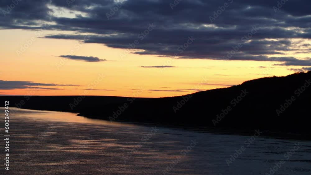 Aerial Panning Shot Of Rippled Sea By Silhouette Hill Against Orange Sky At Sunset - Bering Sea, Alaska Aerial Panning Shot Of Rippled Sea By Silhouette Hill Against Orange Sky At Sunset - Bering Sea, Alaska
