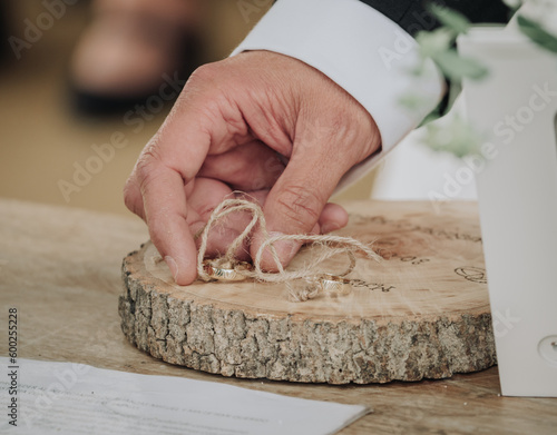 Fototapete Mano del novio cogiendo el anillo de la novia