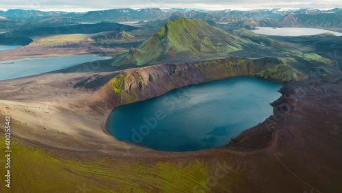 Aerial drone footage of Blahylur Volcanic Crater Lake and Mossy Mountain in Landmannalaugar Iceland Nature Highlands. Famous tourist attraction and landmark destination. Pan right descend. photo