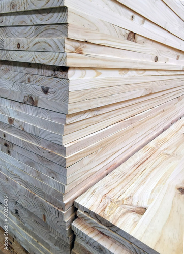 Closeup on the side of a pile of lumber, stocked for sale.